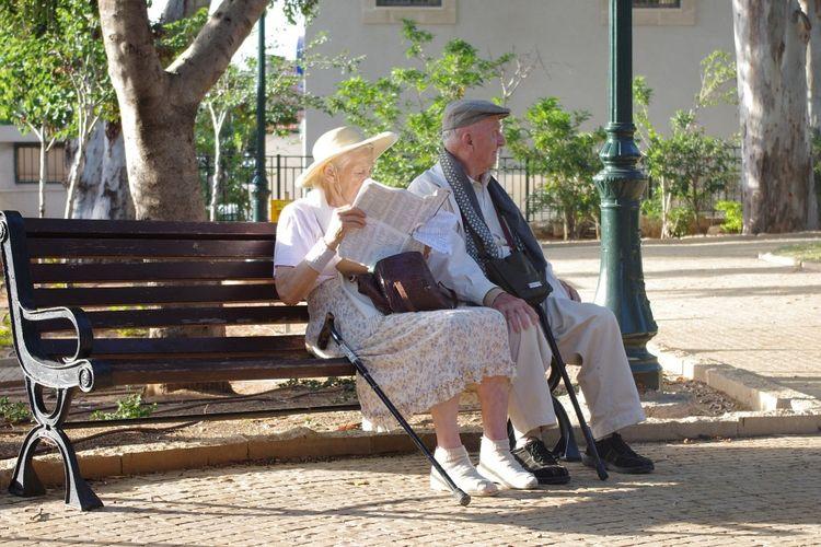 Deux séniors assis sur un banc public